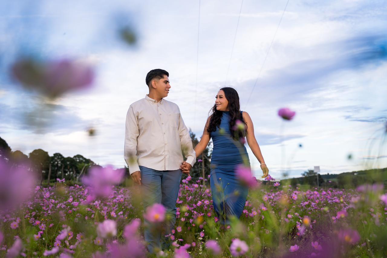 Cindy y José tomados de la mano en un campo de flores