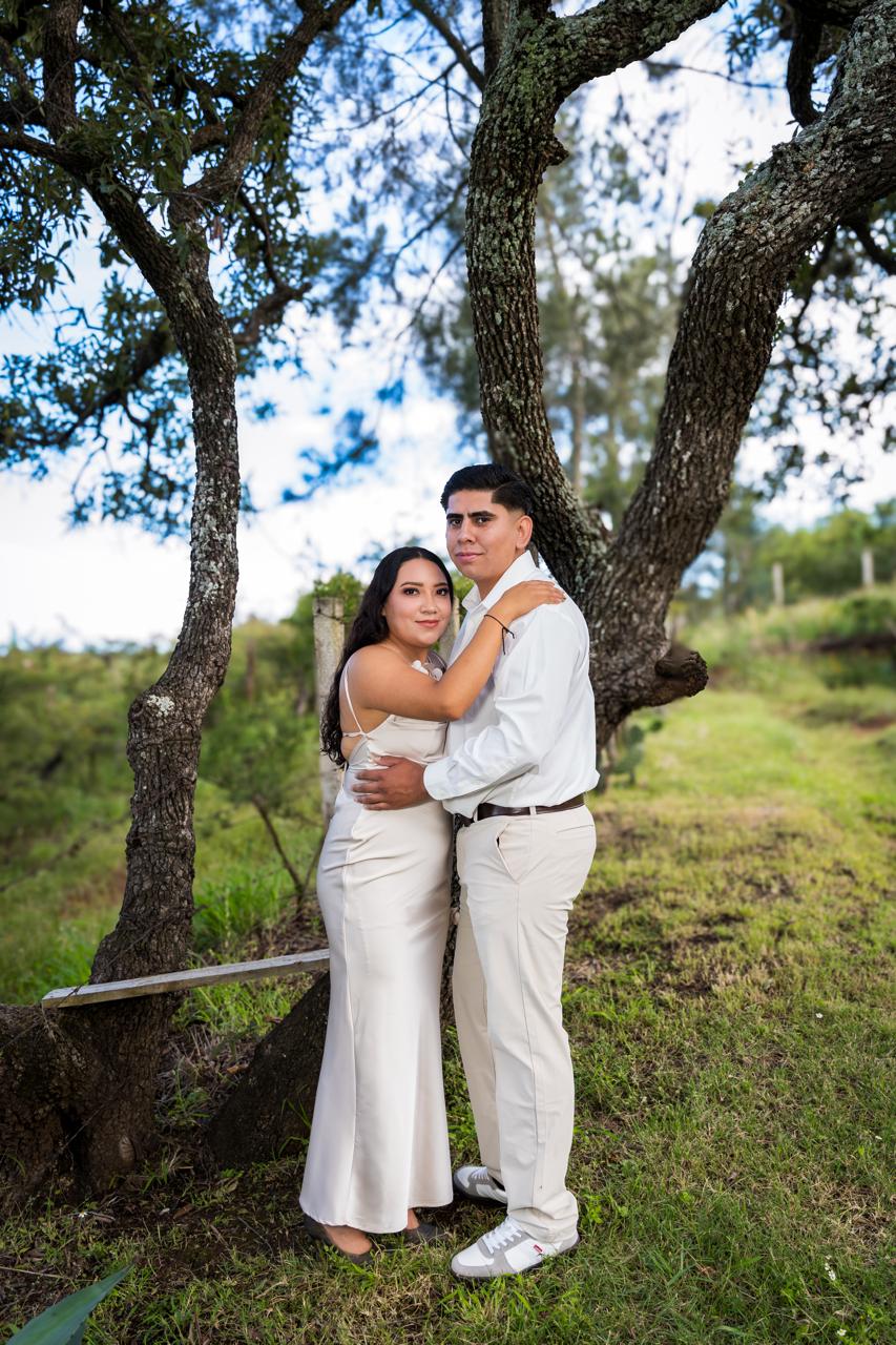 Cindy y José abrazados bajo un árbol